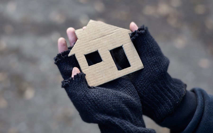 Photo of hands holding a piece of cardboard cut to look like a house