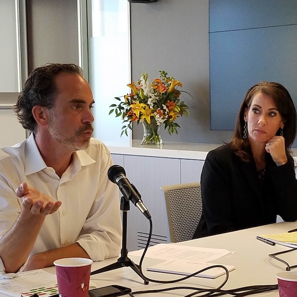 Two people talking at a table with mics