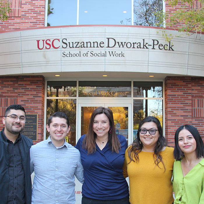 A group of people standing in front of the USC Suzanne Dworak-Peck building