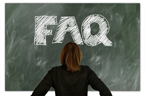 Person standing in front of chalk board that says "FAQ"