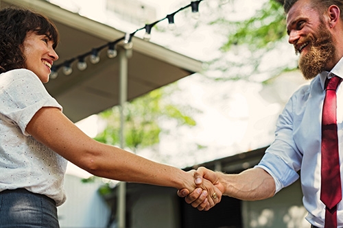 Two people shaking hands and smiling