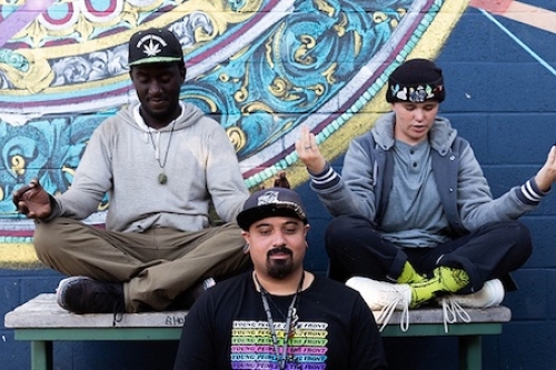 three men meditating in from of a mural