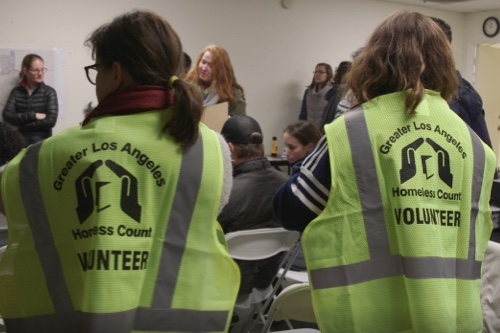 Two people with yellow vests that say "Greater Los Angeles Homeless Count Volunteer"