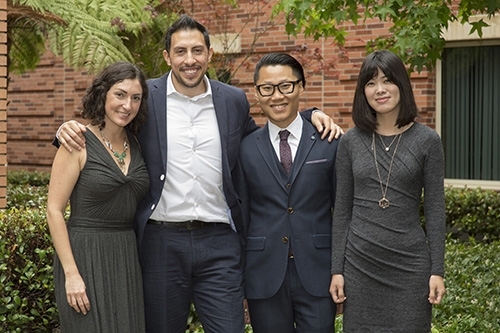 Four PhD students standing together smiling